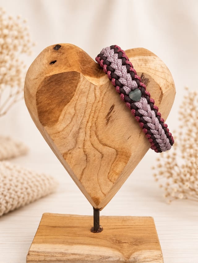 Paracord-Halsband „Beerenglanz“ in Sangria, Espresso und Diamonds & Pastel Pink mit Aventurin-Herz, frontal auf einem Holzherz